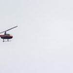 A panoramic shot of a helicopter flying in a cloudy sky